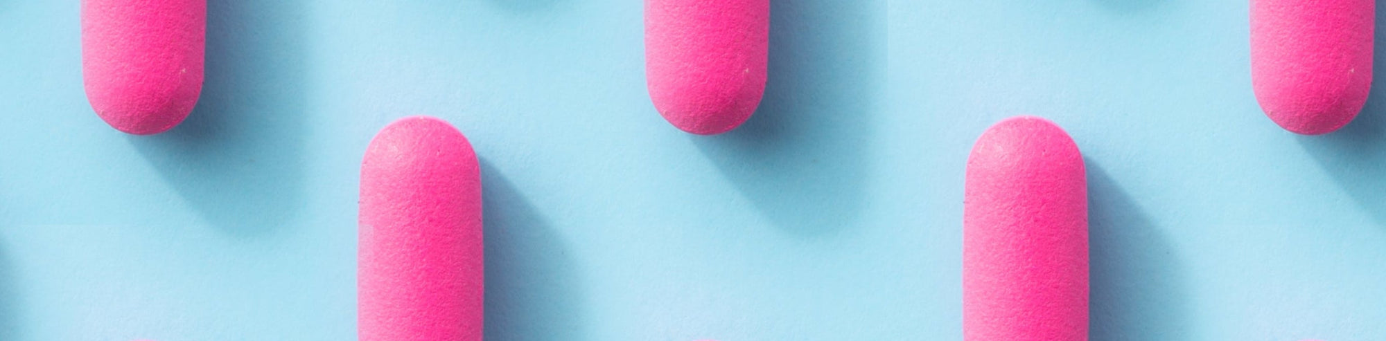Pink makeup sponges arranged in a grid on a blue background